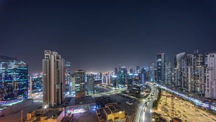 Obraz na płótnie Canvas Water canal with modern towers residential development in Business Bay aerial panoramic all night timelapse, Dubai