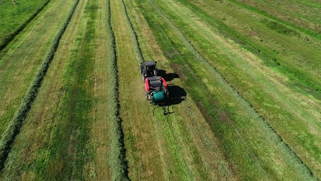 Treker mit einer Stroh Festkammerpresse bei der Strohernte auf einem gem&auml;hten Feld