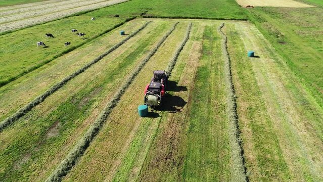 Treker mit einer Stroh Festkammerpresse bei der Strohernte auf einem gem&auml;hten Feld