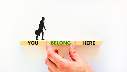 You belong here symbol. Concept words You belong here on beautiful white table white background. Businessman hand. Diversity, business, inclusion and belonging concept. You belong here quote.