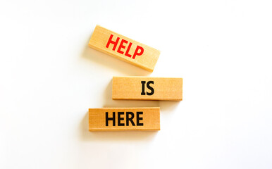 Help is here and support symbol. Concept words Help is here on wooden blocks on beautiful white...