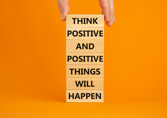 Think positive symbol. Wooden blocks with words Think positive and positive things will happen. Beautiful orange background copy space. Businessman hand. Business, motivational think positive concept.