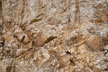 Weathered granite rock in sunlight as texture or background