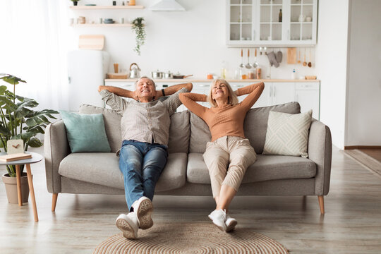 Happy Senior Couple Relaxing Sitting On Sofa At Home