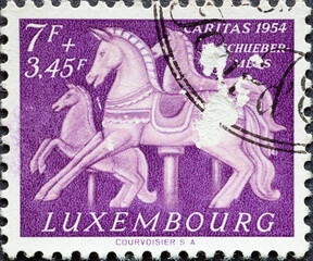 Luxembourg - circa 1954: a postage stamp from Luxembourg, showing Carousel Horses