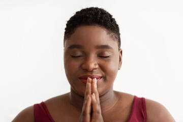 Fototapeta na wymiar Closeup portrait of peaceful overweight black lady meditating