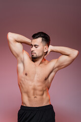 Fototapeta premium lighting on shirtless man with muscles posing on pink and grey.