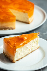 A piece of peach cheesecake on a white ceramic plate. banner, menu, recipe place for text, top view
