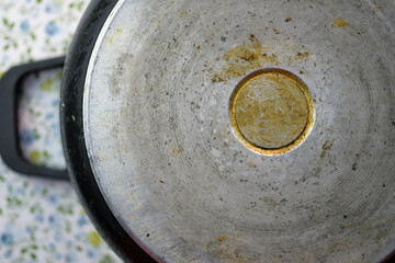 The reverse side of the pan is a top view. An old metal pan with drops of fat. The bottom of the cooking pot.