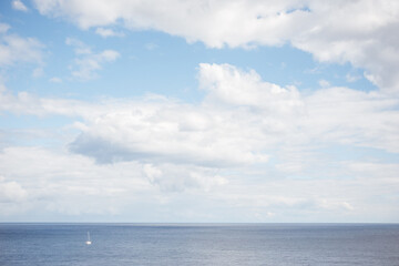 Naklejka na ściany i meble Sea and sky view with little white boat.