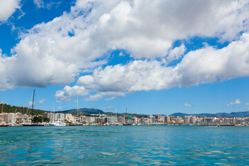 View of the bay of Palma de Mallorca with yachts, buildings, mountains and beautiful clouds.