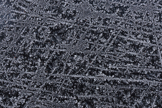 Frozen pattern of hoarfrost and frostwork structure on the dark glass. Color photo for background. No2.