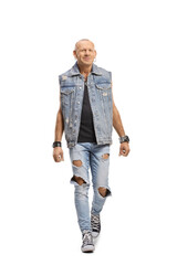 Bald man in a denim vest walking towards camera