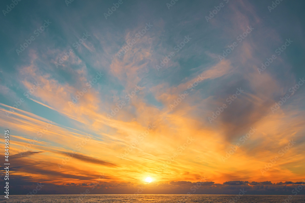 Wall mural magnificent view of blurry cirrus clouds with gorgeous light and a solar disk over the horizon of th