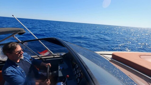 Man driving motor boat on sea. Tourism, vacation, speed, outdoor, sailor, boat, sunglasses, sea.