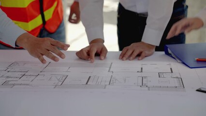 civil engineering team Along with the architect and foreman watching the Blue Print and planning the construction of the building on the construction site.
