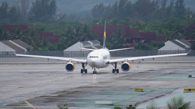 Airbus A330 of Thomas Cook taxiing to the runway before departure at Phuket Airport. Passenger plane on the airfield. Tourism and travel concept