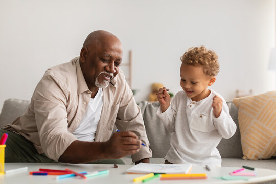 Happy Black Little Boy And Grandpa Drawing Picture At Home
