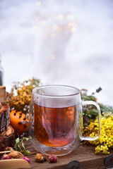 Tea from the collection of medicinal herbs and honey on a background of snow. Healthy food, winter tea for colds