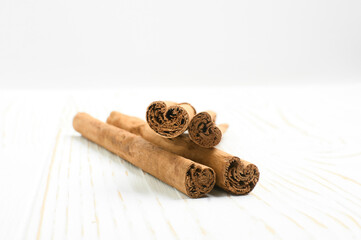 cinnamon sticks on white wooden background