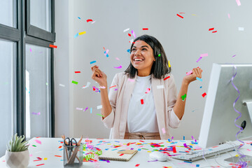 Young business woman having fun time catching confetti - obrazy, fototapety, plakaty