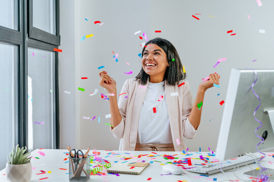 Young business woman having fun time catching confetti