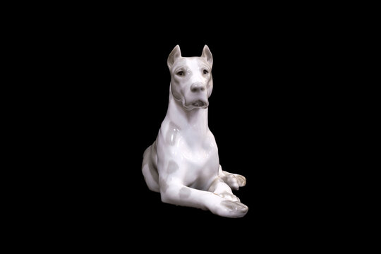 a dog of the White Great Dane breed is isolated on a black background. porcelain figurine