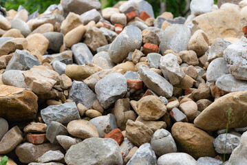 A pile of stones and after dismantling a stone house. Stones used in the cladding of an old house.