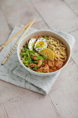 Egg noodles with spicy sauce, green onions, fried chicken, boiled egg. Soup with noodles and poultry meat in Thai style. Eat with chopsticks