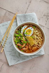 Egg noodles with spicy sauce, green onions, fried chicken, boiled egg. Soup with noodles and poultry meat in Thai style. Eat with chopsticks