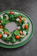 Spinach, kale, cherry tomato, burrata, mozzarella and avocado salad with sesame and flax seeds. A healthy lunch of fresh vegetables, cheese and young greens. Unusual food styling