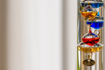 Galileo thermometer with bright colors and reflections in different backgrounds