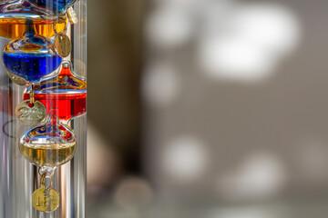 Galileo thermometer with bright colors and reflections in different backgrounds