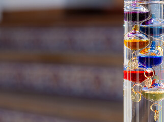 Galileo thermometer with bright colors and reflections in different backgrounds