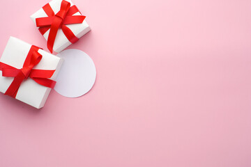 White boxes with gifts on a pink background. St. Valentine's Day. Sheet for text. Concept of love and spring. Top view, background, copy space