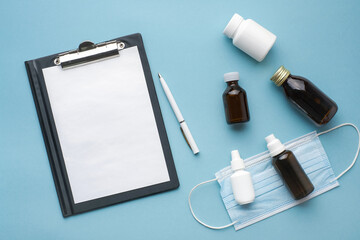 Tablet for writing with an empty white sheet and a pen. Medicine jars. The concept of medical prescriptions and drug prescriptions. Mock up doctor's desk