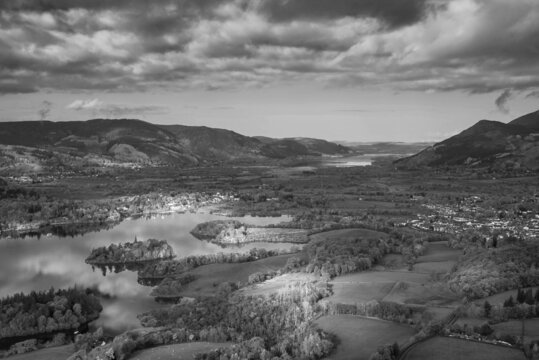 Black and white Beautiful landscape Autumn image of view from Walla Crag in Lake District, over Derwentwater looking towards Catbells and distant mountains with stunning Fall colors and light