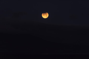 Landscape image of part lunar eclipse during November 2021 which conincided with blood red moon phoase