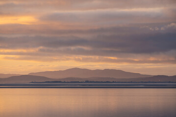 Fototapeta premium Beautiful sunset landscape image of Solway Firth viewed from Silloth during stunning Autumn sunset with dramatic sky and cloud formations