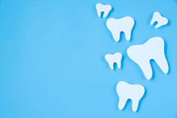 Paper cut mockup of tooth on blue background. Dental care concept. International Dentist Day.