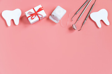 Dental care concept. Dental tools on pink background. Happy dentist day. Paper cut mockup of tooth.