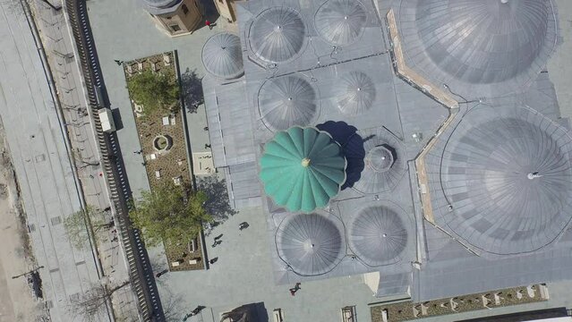 Aerial drone shot over Mevlana Rumi tomb mosque dergah green dome domes city snow cars streets people traffic old town wide shot Karatay, Konya