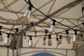 garlands of decorative large light bulbs against the backdrop of mountains