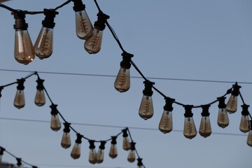 garlands of decorative large light bulbs against the backdrop of mountains