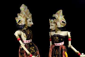 A couple of Wayang Golek of Rama and Shinta with duotone highlight isolated on black background. Wayang golek is one of the traditional Sundanese puppet arts made from wood from West Java, Indonesia.