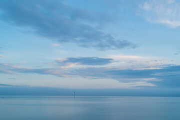 Obraz na płótnie Canvas Cloudy blue minimalist seascape. Deserted space with horizon line.