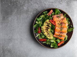 Salmon fish fillet with fresh salad, avocado top view.