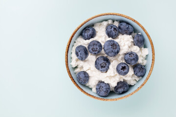 Cottage cheese with blueberry, fresh berries, keto healthy breakfast concept, top view.