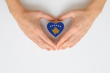 Obraz premium The national flag of Kosovo in female hands. The concept of patriotism, respect and solidarity with the citizens of Kosovo.