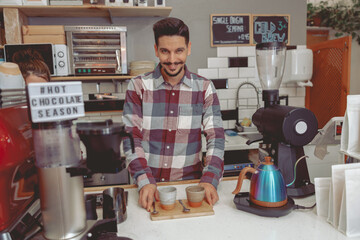 Portrait of smiling barista with mustache serving customers